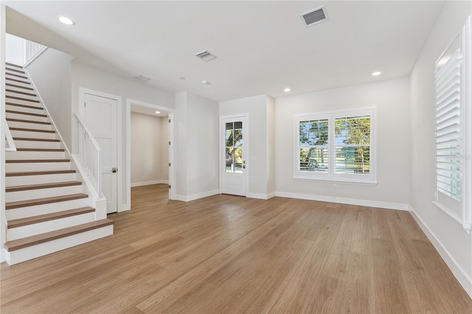 The front room offers natural light, recessed lighting, and a view of the staircase. - 3456 FAIRWAY LN, ORLANDO