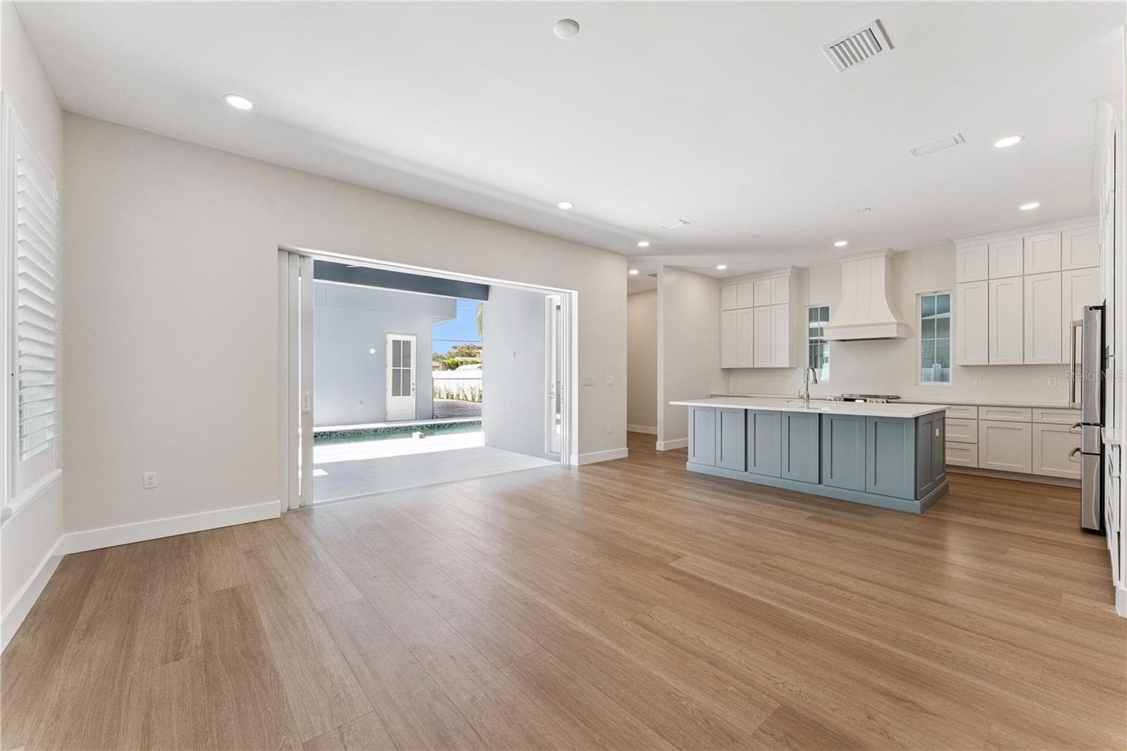 Side sliding glass doors connect the main living area with the covered rear patio. - 3456 FAIRWAY LN, ORLANDO