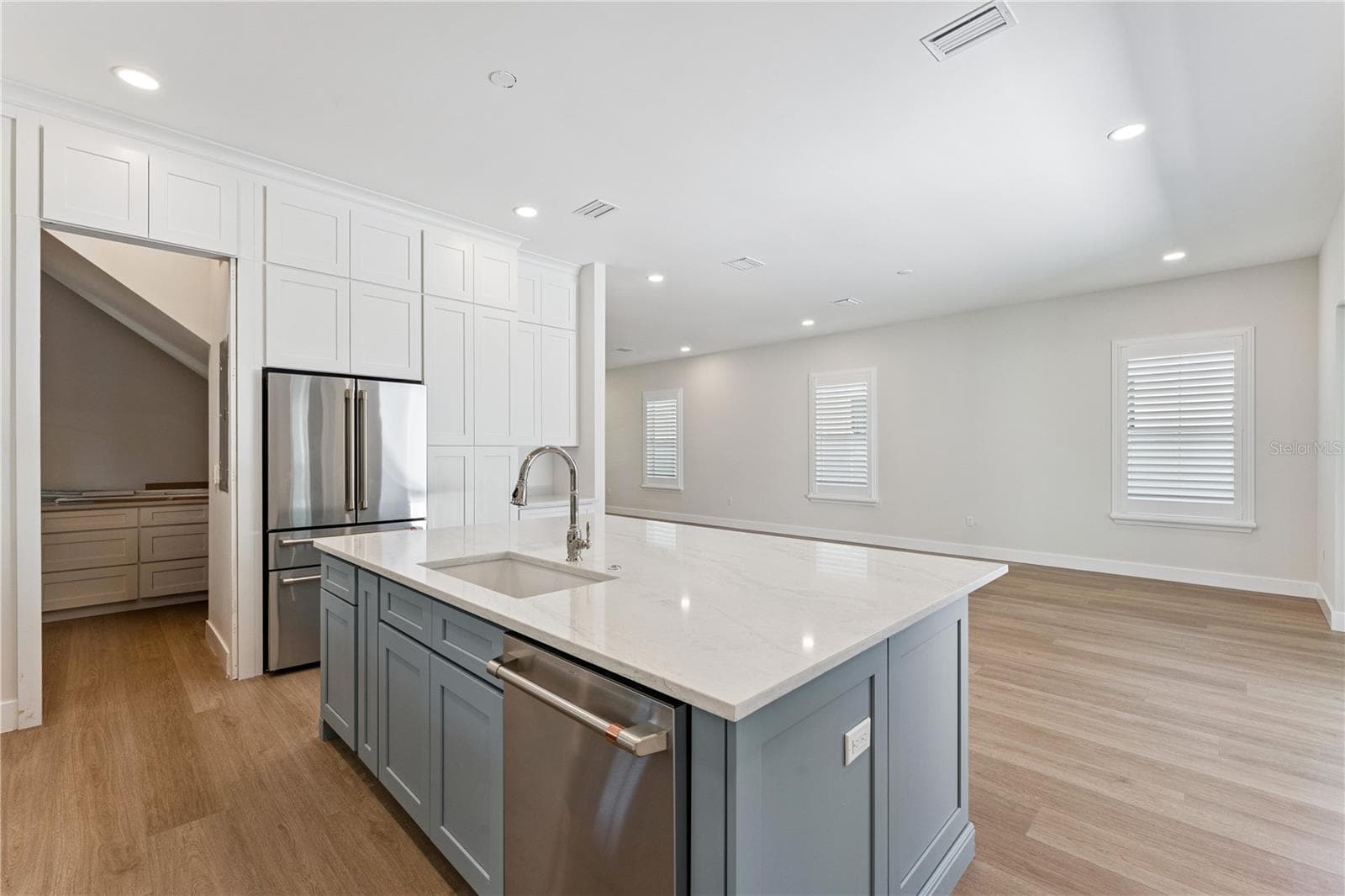A closer view of the blue kitchen island highlights the sink, dishwasher, and surrounding cabinetry. - 3456 FAIRWAY LN, ORLANDO