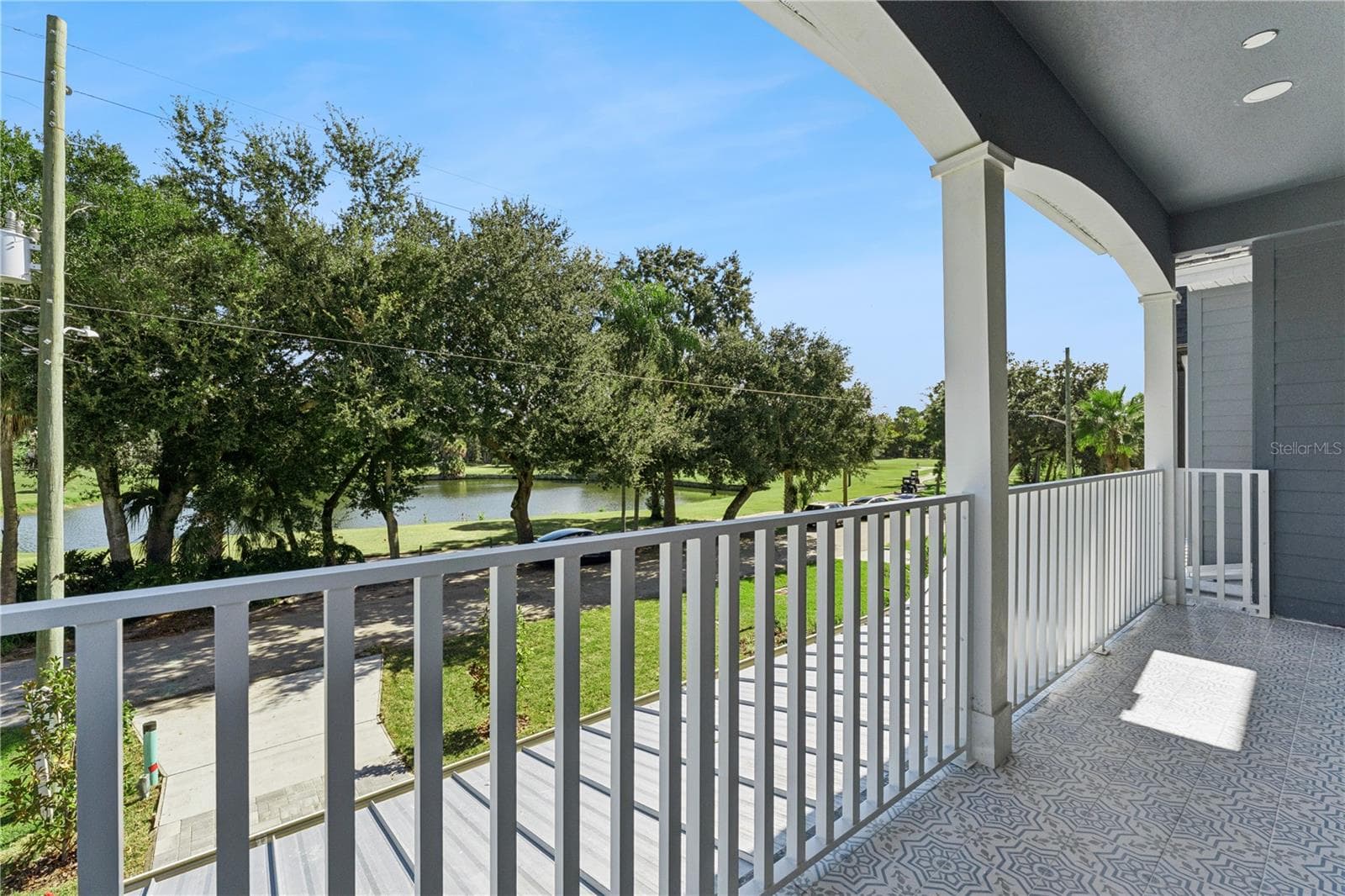 The covered front balcony offers an elevated outlook toward the golf course and surrounding trees. - 3456 FAIRWAY LN, ORLANDO