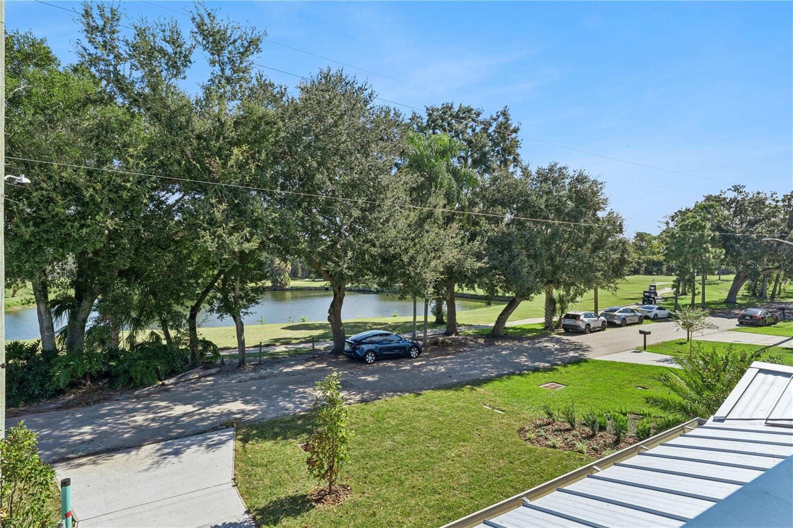 An upper-level outlook takes in the pond and trees across the street. - 3456 FAIRWAY LN, ORLANDO