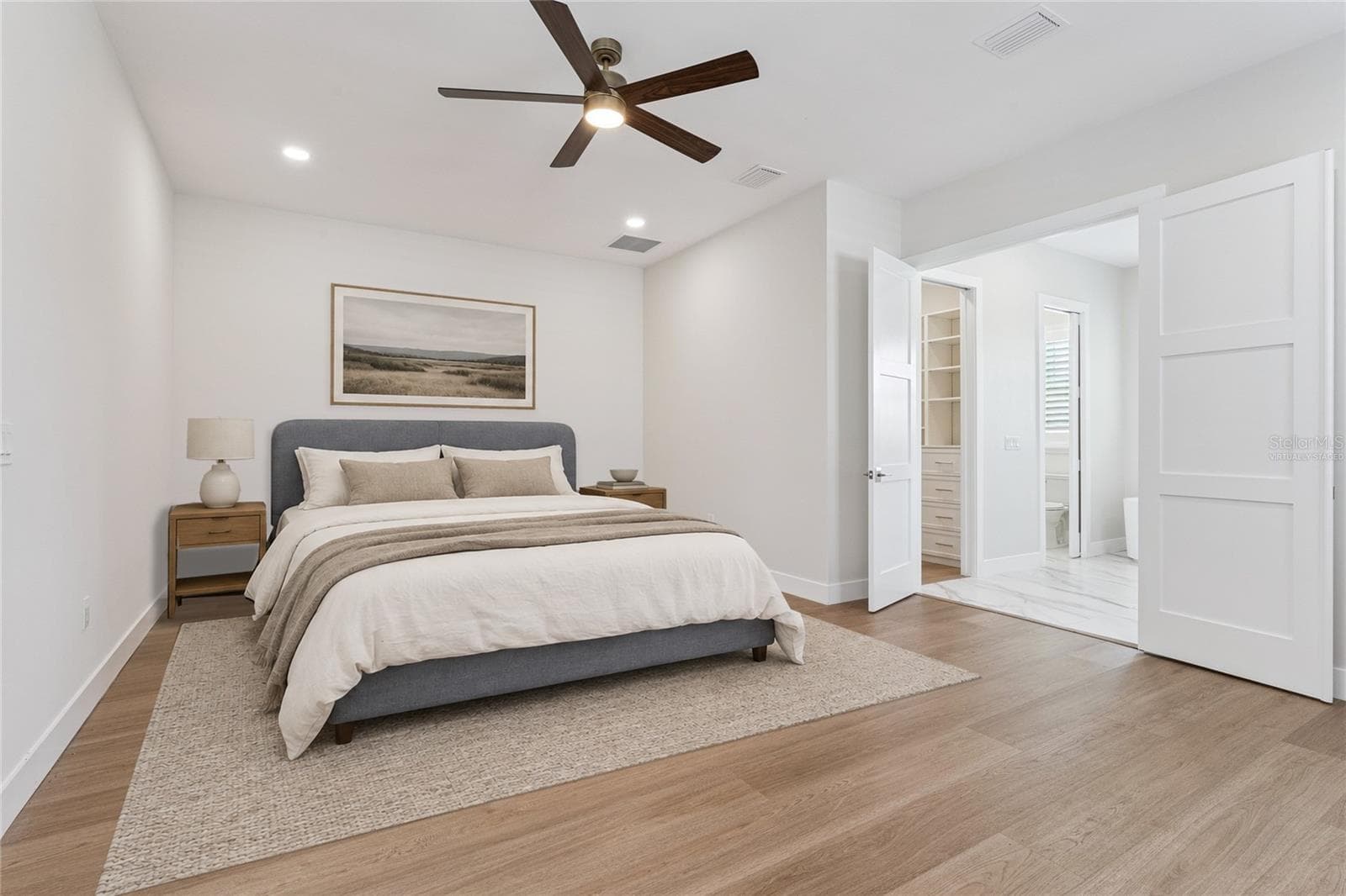Virtually Staged - The primary bedroom features a ceiling fan and a view toward the adjoining bathroom. - 3456 FAIRWAY LN, ORLANDO