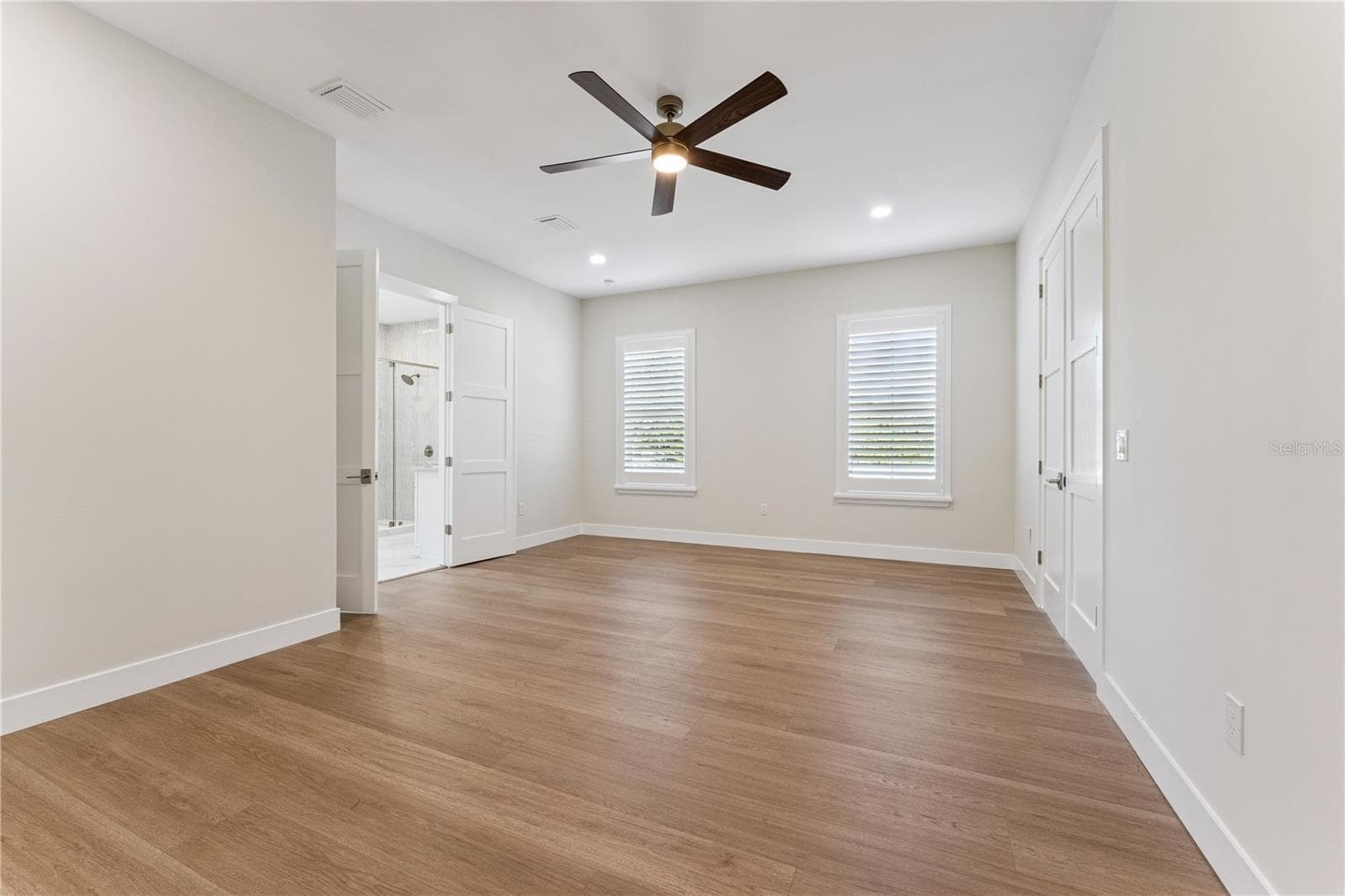 A second view of the primary bedroom shows its windows and open floor space. - 3456 FAIRWAY LN, ORLANDO