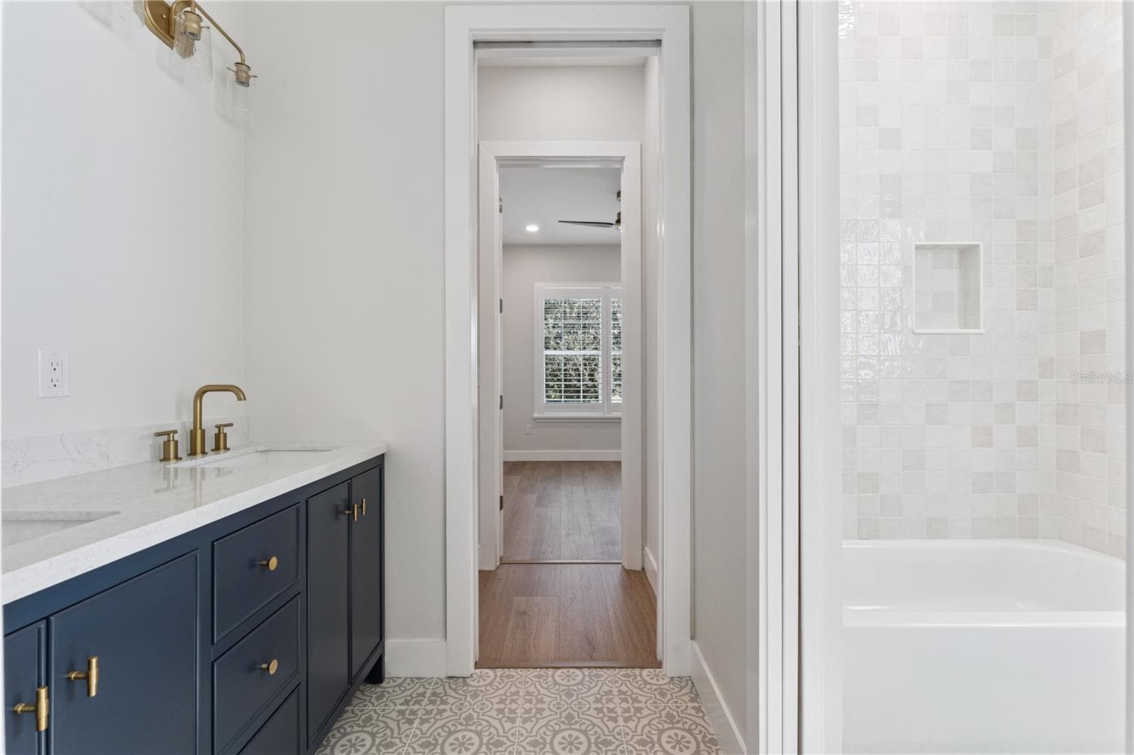 A navy double vanity pairs with patterned flooring and a tub-and-shower combination. - 3456 FAIRWAY LN, ORLANDO