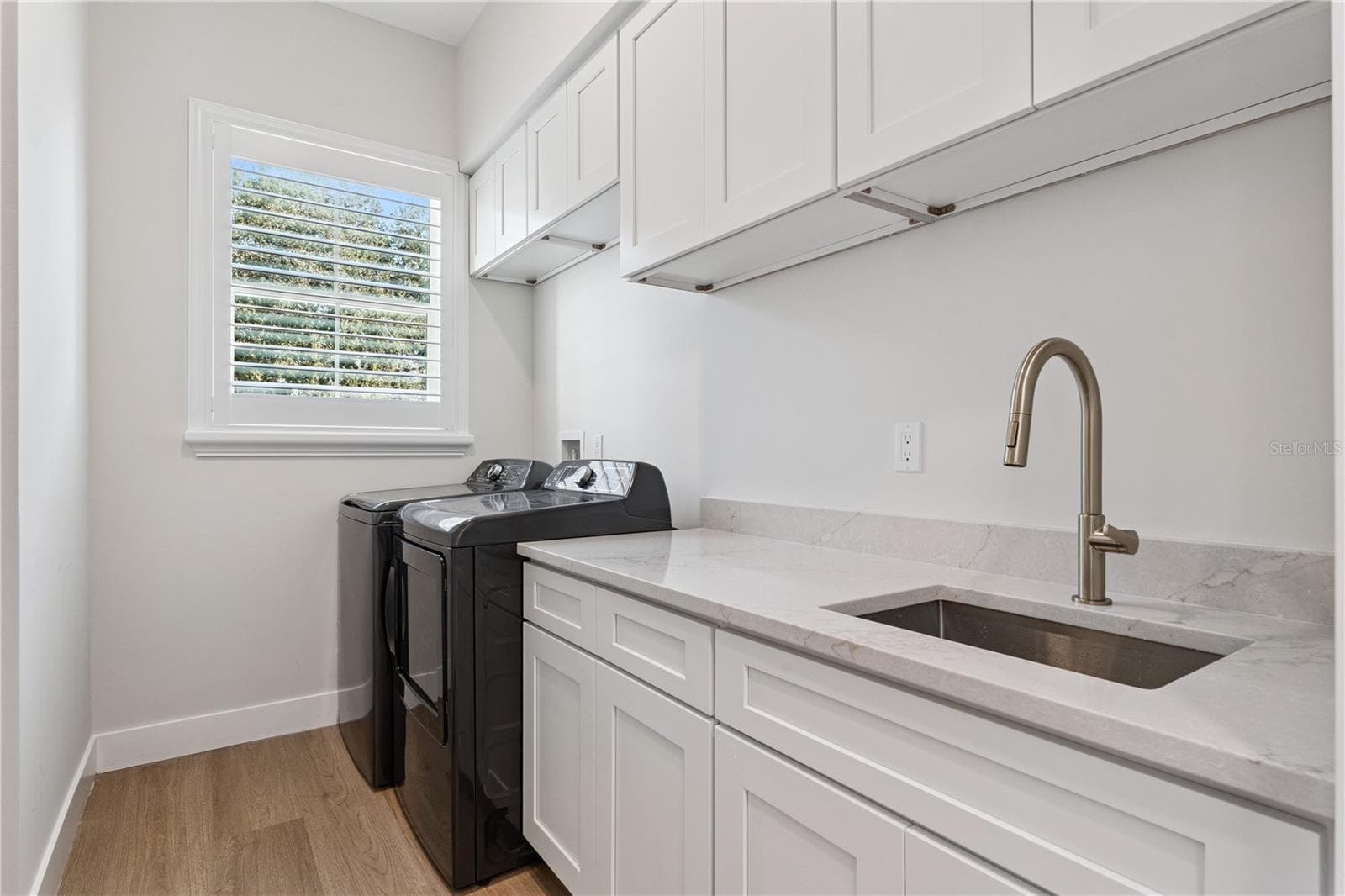 The laundry room includes a washer, dryer, utility sink, and upper and lower cabinetry. - 3456 FAIRWAY LN, ORLANDO