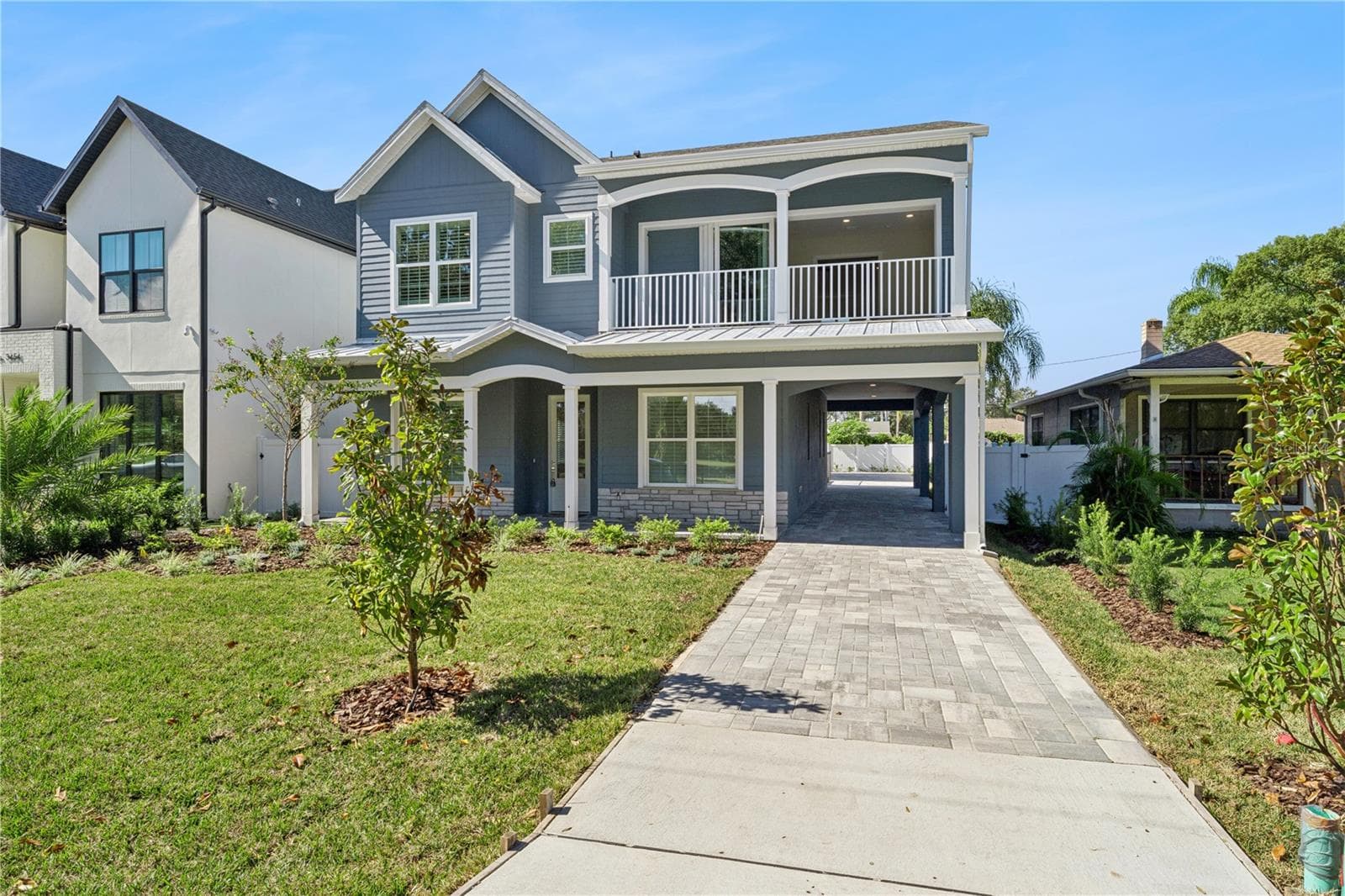 A driveway-side view shows the home's front porch, balcony, and covered side passage. - 3456 FAIRWAY LN, ORLANDO