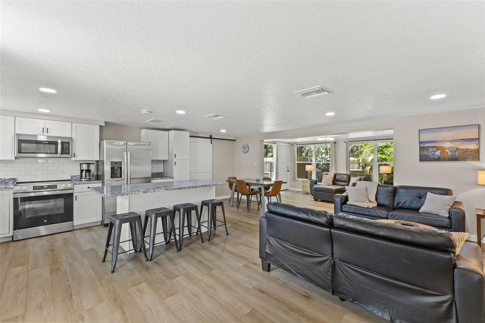 The renovated kitchen opens to the main living areas and features new cabinetry, granite countertops, stainless steel appliances, and a large gathering island. - 201 SOUTH ST, PALM HARBOR