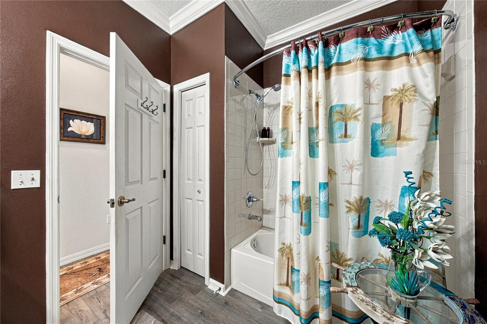 The guest bath has a linen closet and a combination shower and tub with a ceramic tile surround. - 4232 DORNOCH DR, LAKE WALES