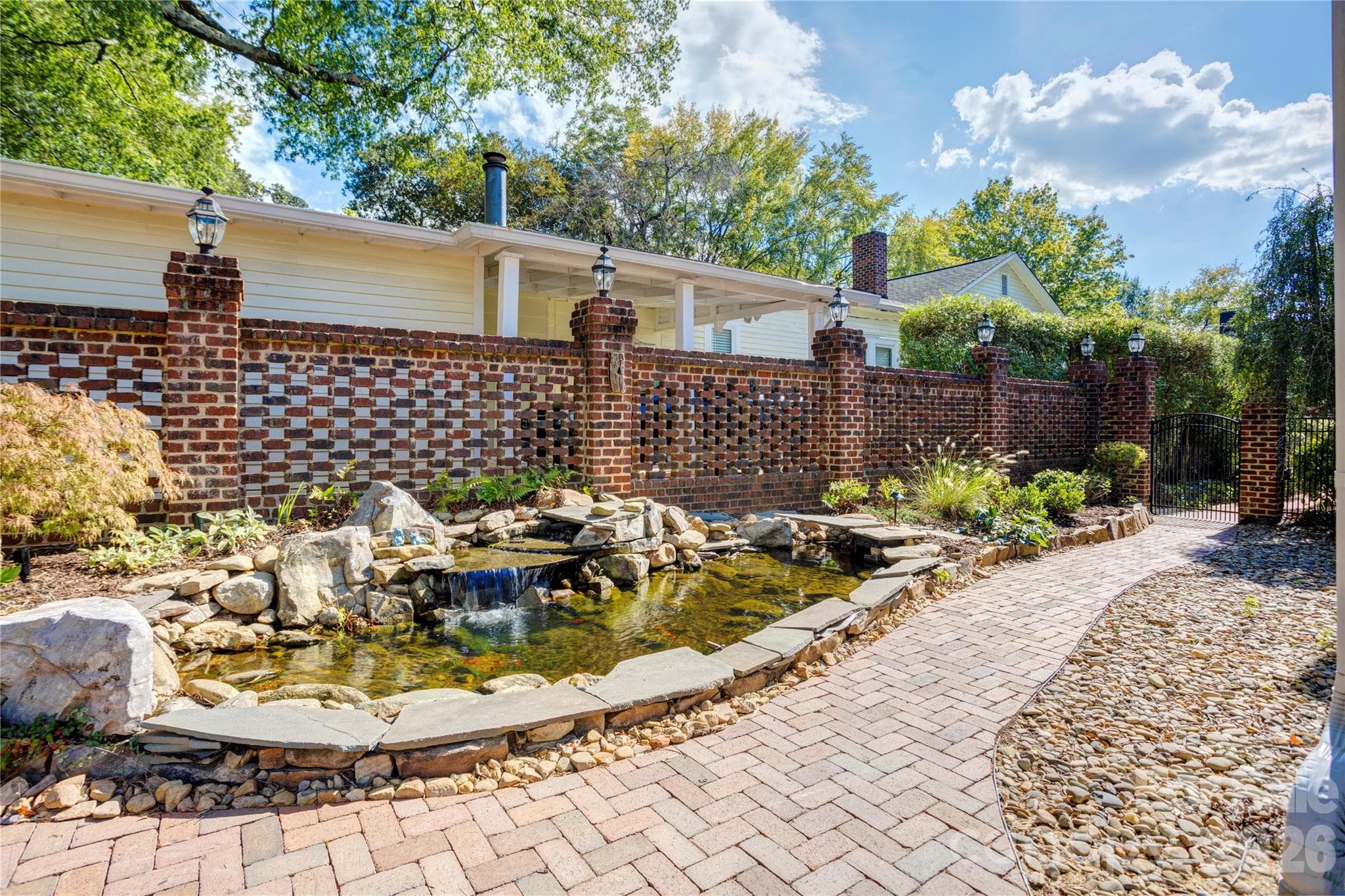 Koi pond with a waterfall and side gate to the front yard. Showcasing the beautiful brick wall - 30 Georgia Street NW, Concord