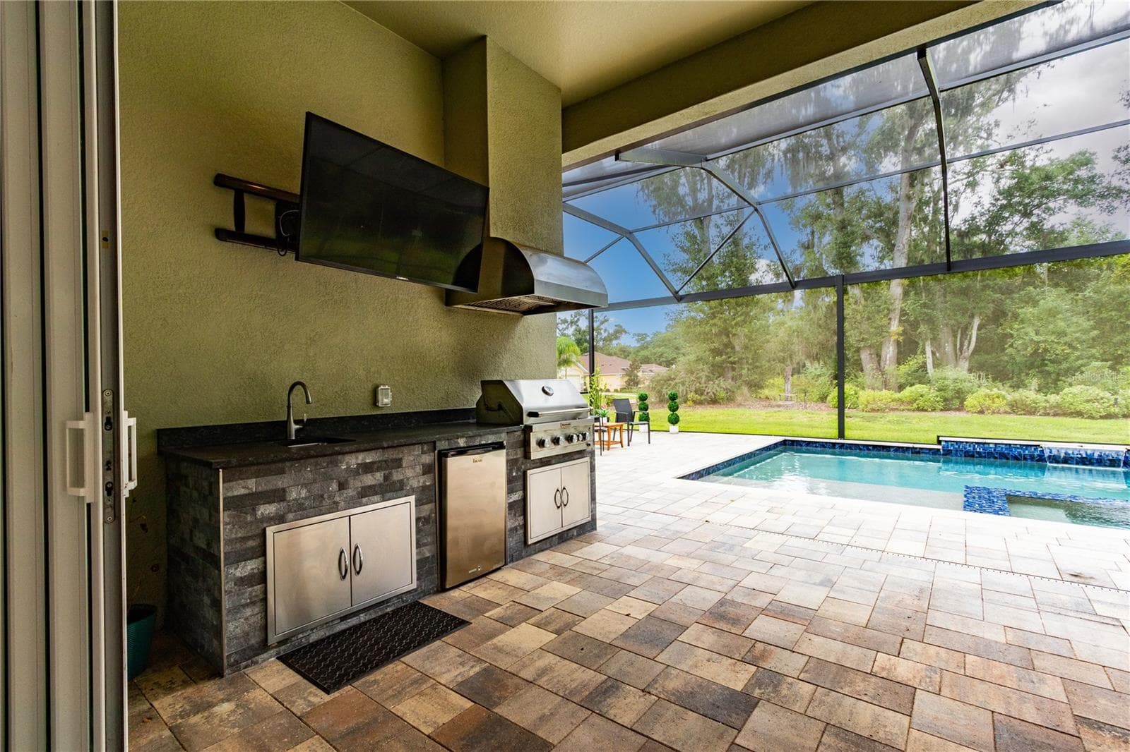 Outdoor kitchen boasts Kitchenaid grill, fridge and sink - 13303 TRAILING MOSS DR, DADE CITY
