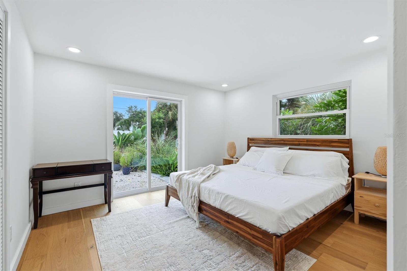 Both of the en-siut bedrooms have private sliding door access to the Bohemian Garden, where the backyard greenery subtly reaches into the rooms, making them true Garden Suite bedrooms - 2513 CROTON AVE, SARASOTA