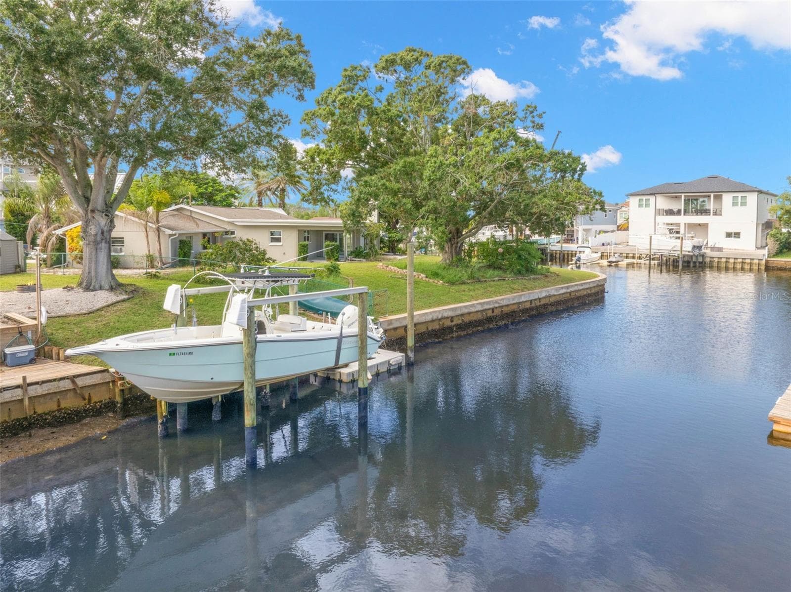 Set along a saltwater canal with Gulf access and no fixed bridges, the property’s 10,000-pound boat lift puts you just steps from getting out on the water. - 332 WESTWINDS DR, PALM HARBOR