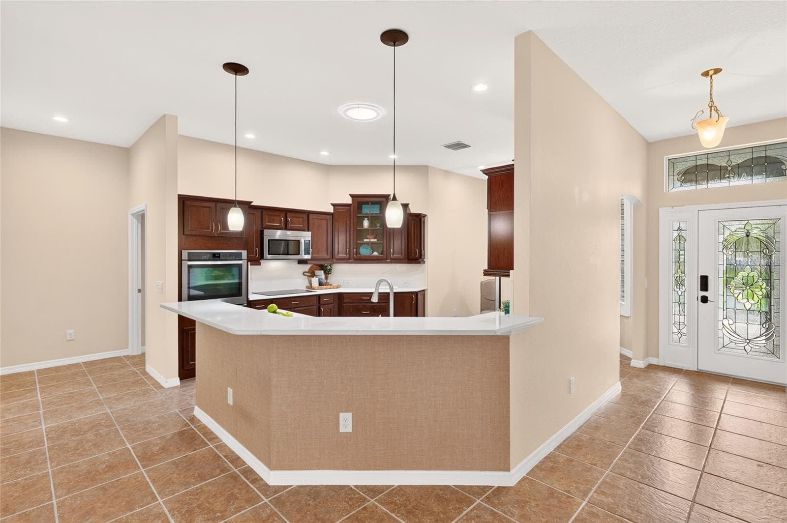 A spacious BREAKFAST BAR connects the beautifully appointed kitchen to the main living area, keeping conversation flowing while you prepare meals or entertain friends. - 2454 MORNING DOVE LN, THE VILLAGES