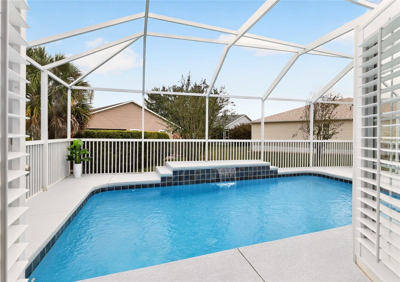 Step directly from the PRIMARY SUITE into your SCREENED POOL RETREAT, where sparkling water and a beautiful WATERFALL FEATURE invite you to relax and savor the Florida lifestyle! - 2454 MORNING DOVE LN, THE VILLAGES