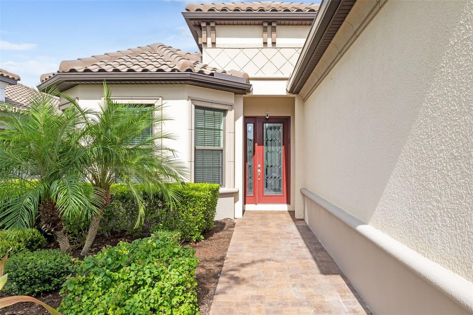 a leaded-glass front door and sidelight adorn the welcoming entry area - 12807 SORRENTO WAY, BRADENTON