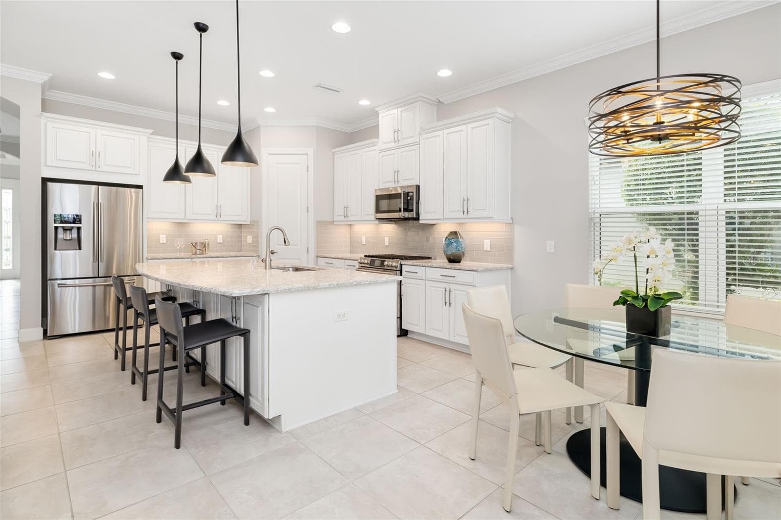 The kitchen area is highlight by designer lighting fixture - 12807 SORRENTO WAY, BRADENTON