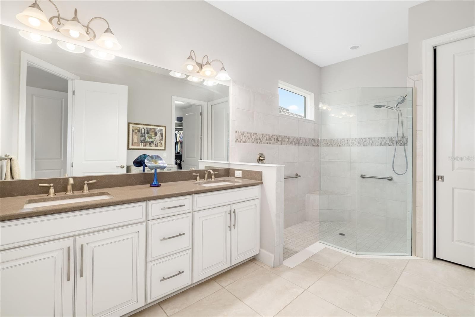Taupe quartz and wide-spread faucets add a touch of elegance to the double vanity ensuite bath. Private water-closet area. - 12807 SORRENTO WAY, BRADENTON