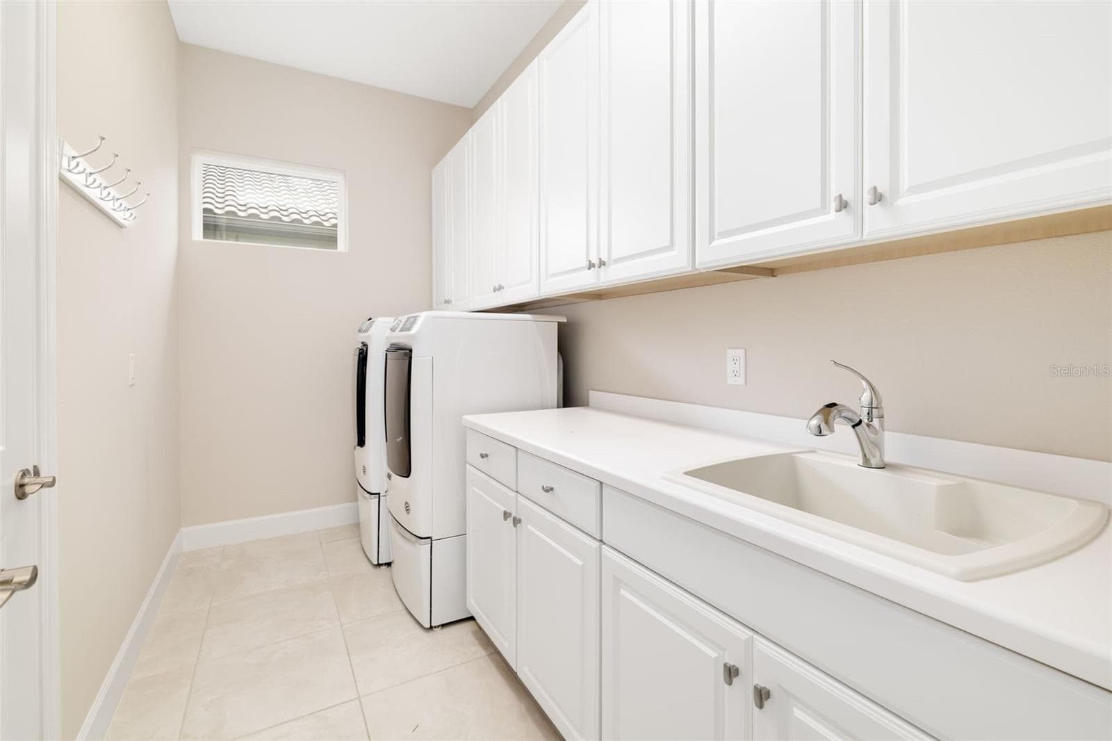 Spacious laundry room boasts an abundance of cabinetry and counter space with sink and includes the washer and dryer - 12807 SORRENTO WAY, BRADENTON