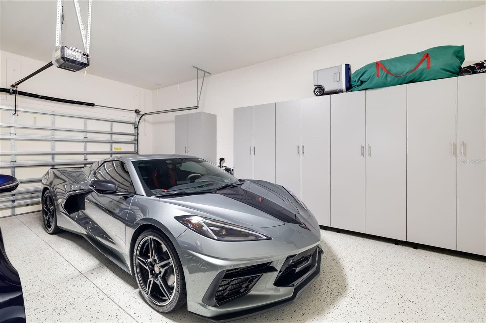 The 525 sq ft, 2 car garage has an epoxy finished floor and a wall of removable storage cabinets - 12807 SORRENTO WAY, BRADENTON