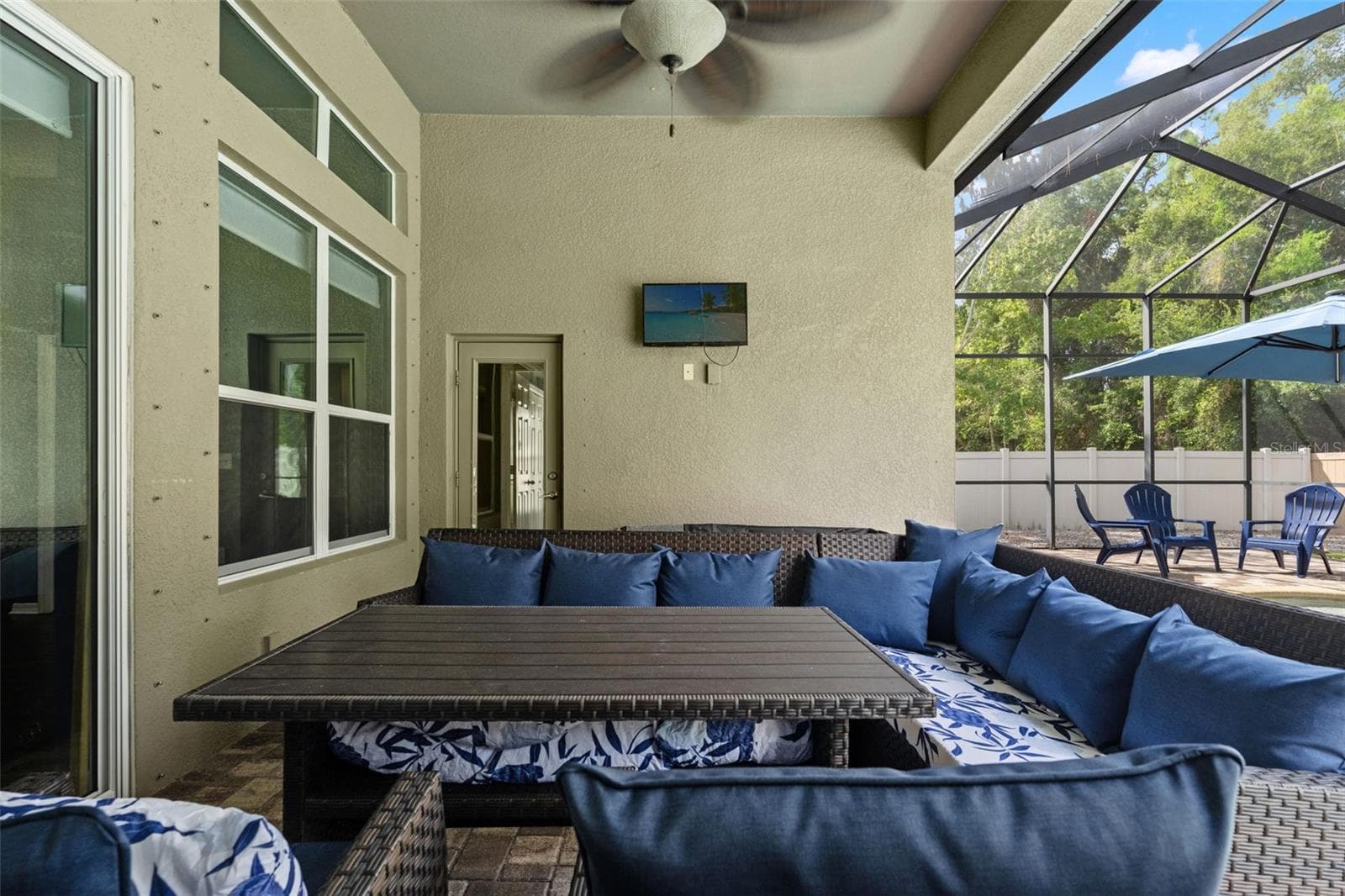 Ceiling fans and a generous covered area make the lanai a comfortable place to relax even when you’re taking a break from the sun. - 1419 BLUE MARLIN BLVD, HOLIDAY