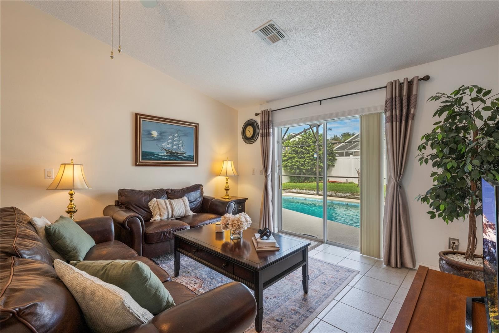 Living room with sliding glass doors to Pool and Patio - 8007 ARROW CREEK RD, KISSIMMEE