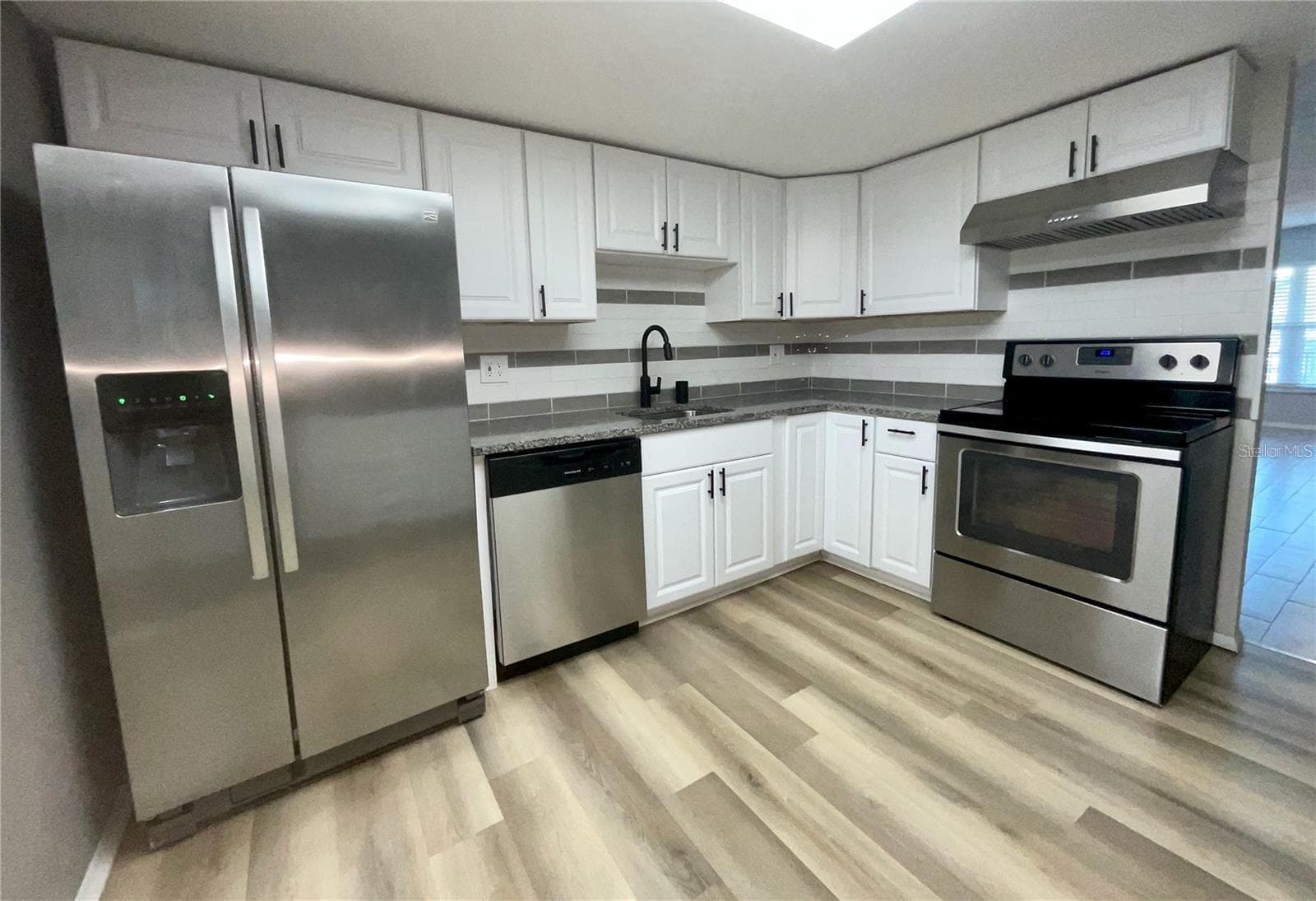 Kitchen sink area with frig, dishwasher and range. - 1020 85TH AVE N #222, ST PETERSBURG