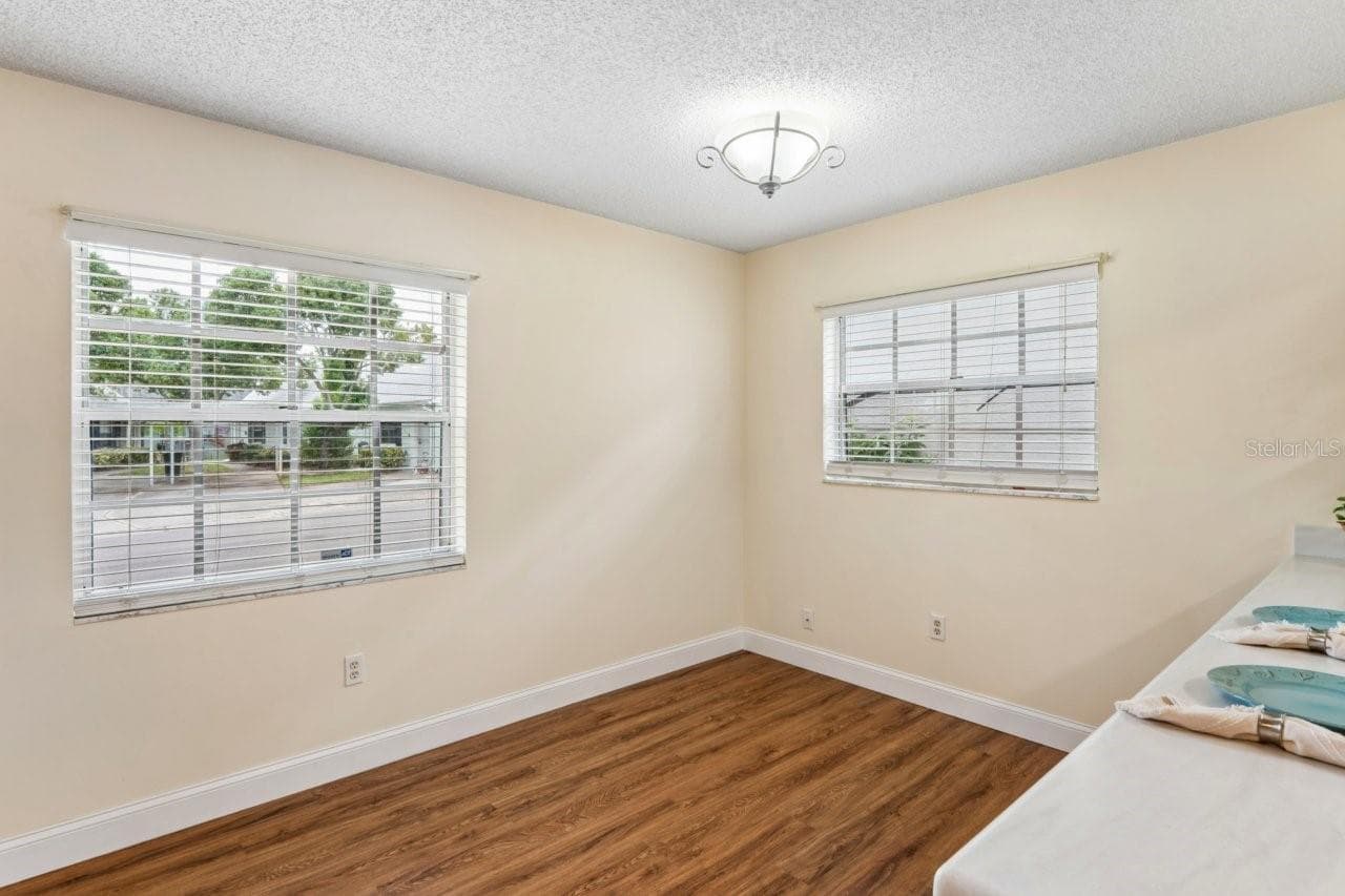 This area is the dining room with access to the breakfast bar and two windows. Newer flooring throughout. - 6709 DEVONSHIRE LN #10A, NEW PORT RICHEY