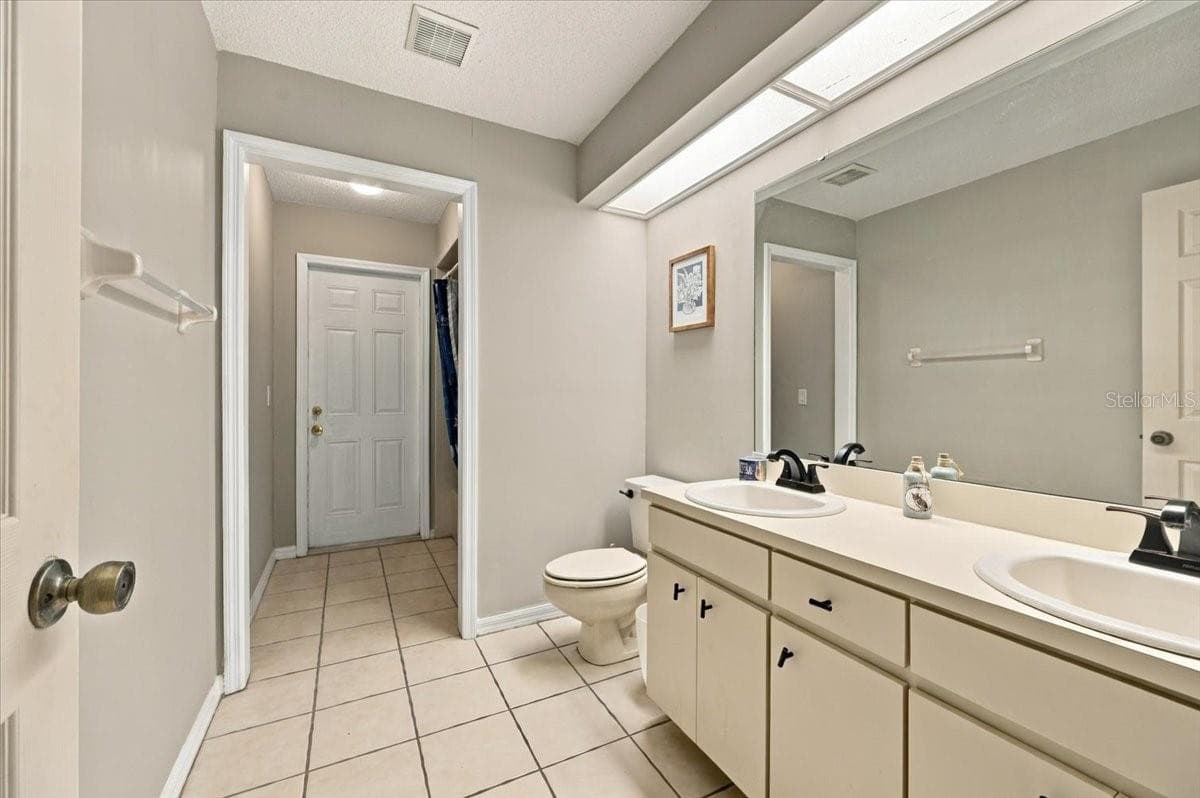 Guest bath with exit to rear patio - 4437 FLINTLOCK LOOP, LAKELAND