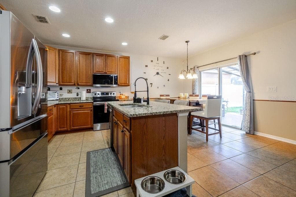 Kitchen and dining area with sliding glass doors to covered back patio - 252 SHERRI LEE LN, DELAND
