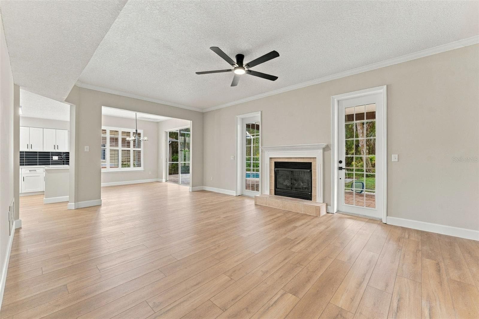 Inviting family room with fireplace and French doors leading to the back porch and pool deck - 10102 VISTA POINTE DR, TAMPA