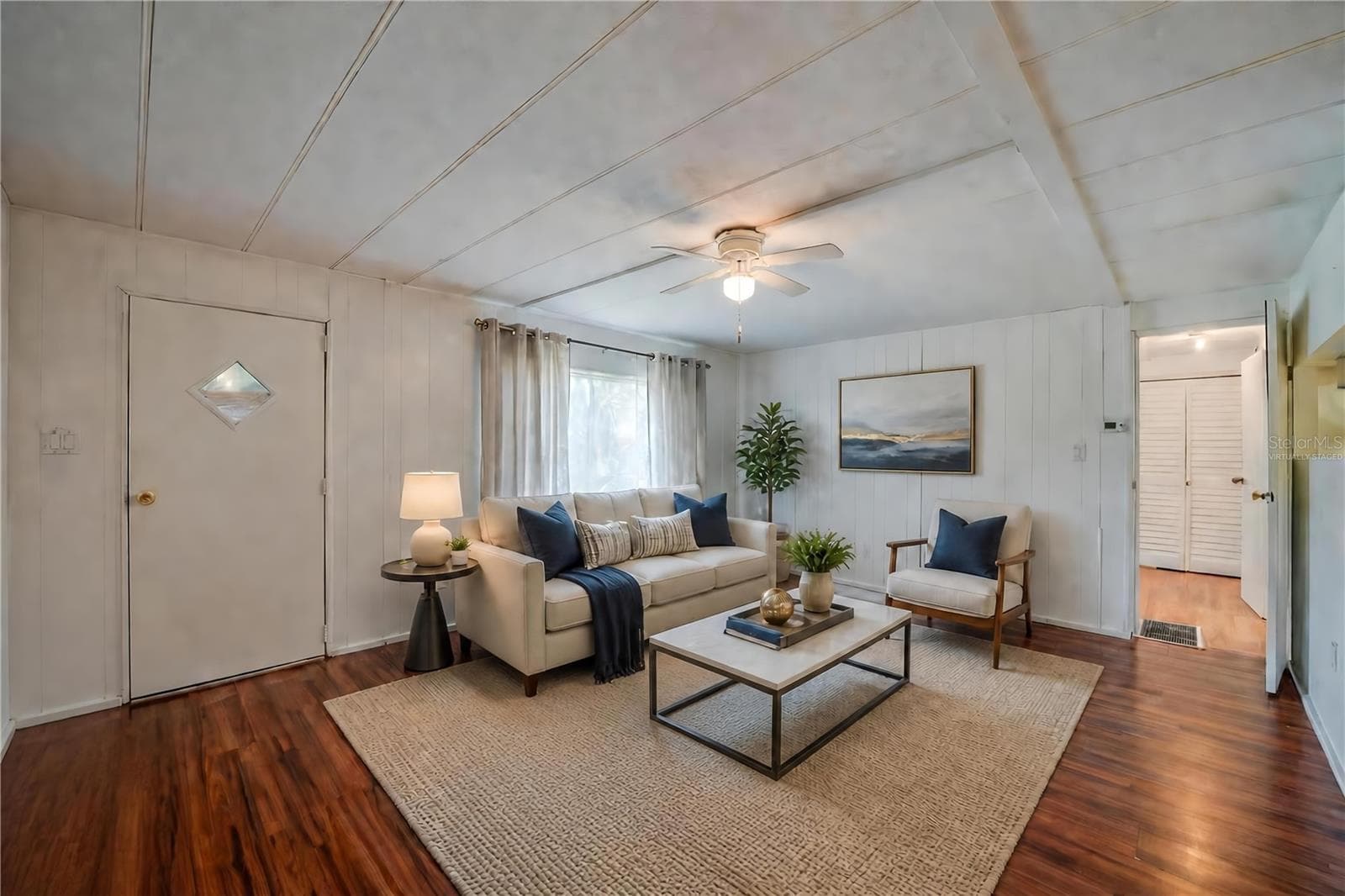 Virtually Staged - Expansive living room offers plenty of flexibility for multiple furniture arrangements, along with a ceiling fan and a large window overlooking the exterior. - 128 KON TIKI TER, PORT ORANGE