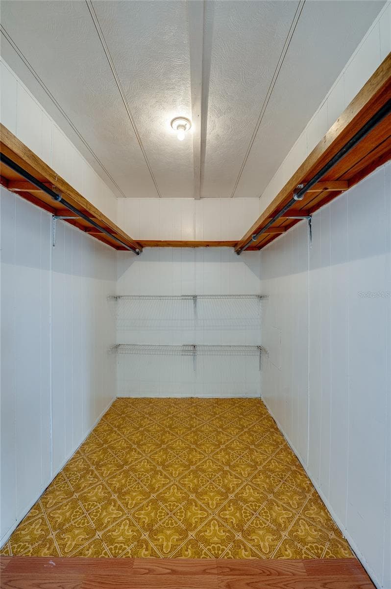 Generously sized walk-in closet provides hanging space and additional shelving for organized storage. - 128 KON TIKI TER, PORT ORANGE