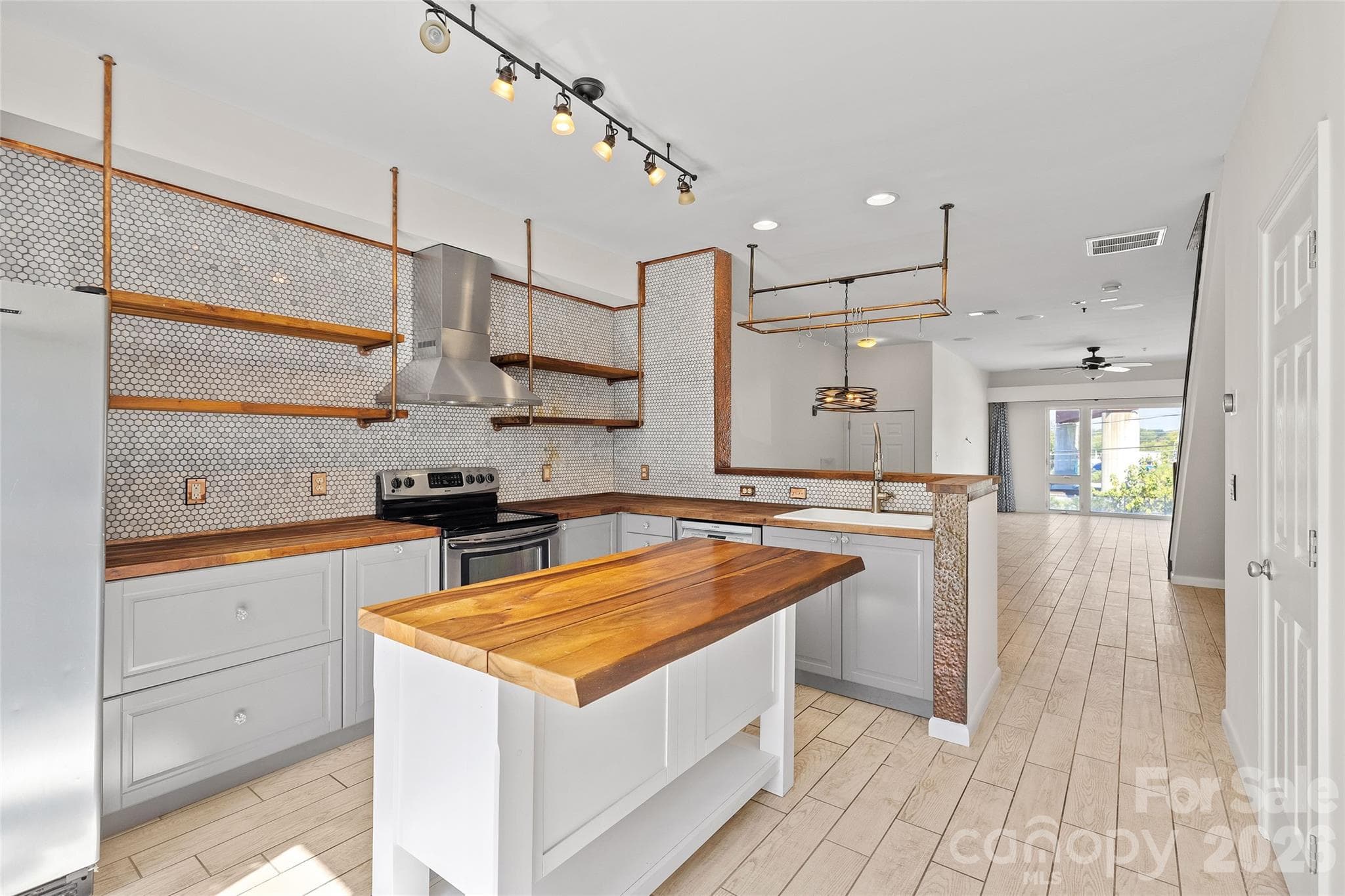 A true custom kitchen with butcher block counter tops and live edge custom industrial shelving - 3564 N Davidson Street, Charlotte