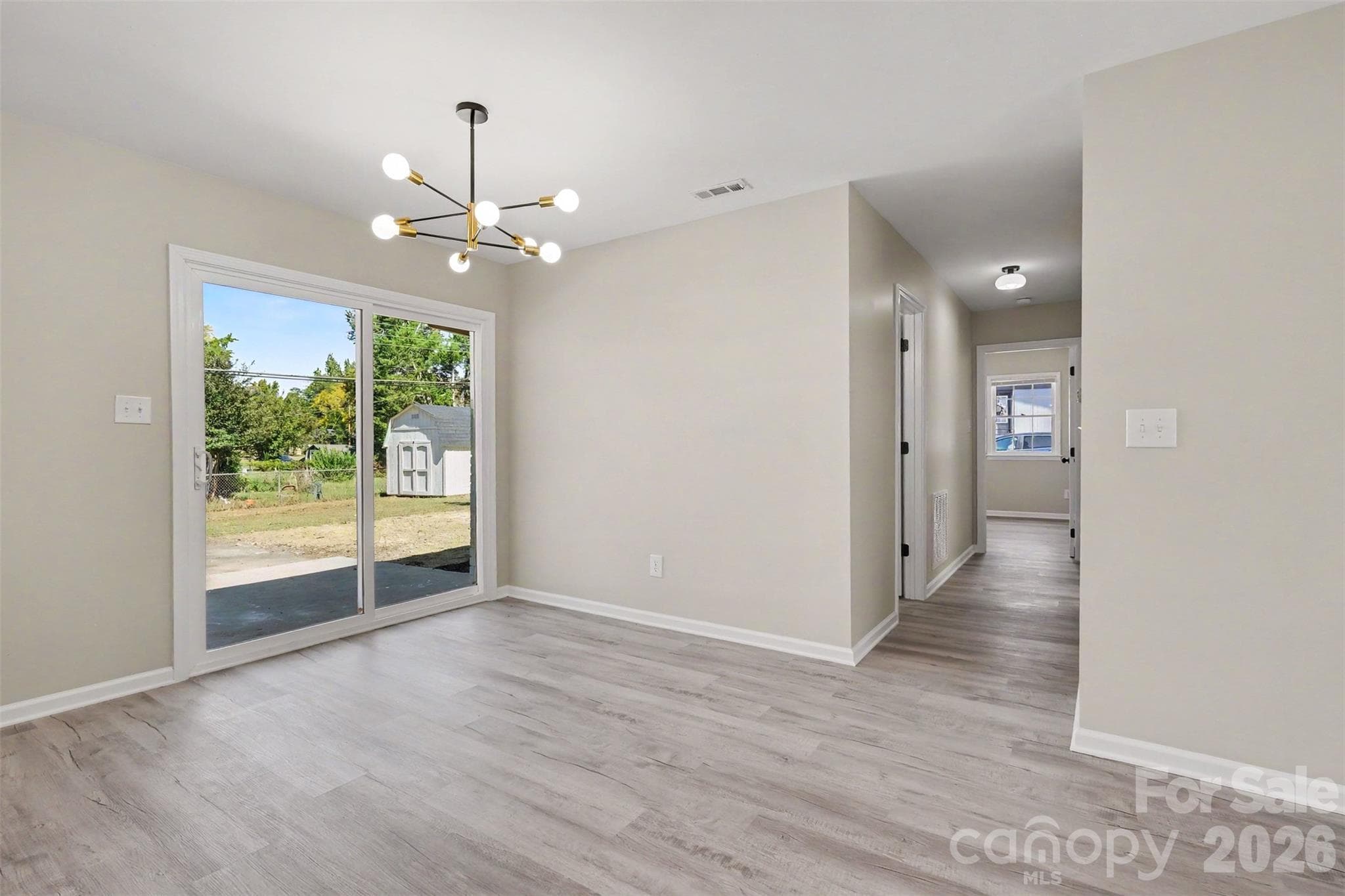 Dedicated dining area featuring a modern light fixture and sliding door access to the rear yard. - 3801 Hillock Court, Charlotte