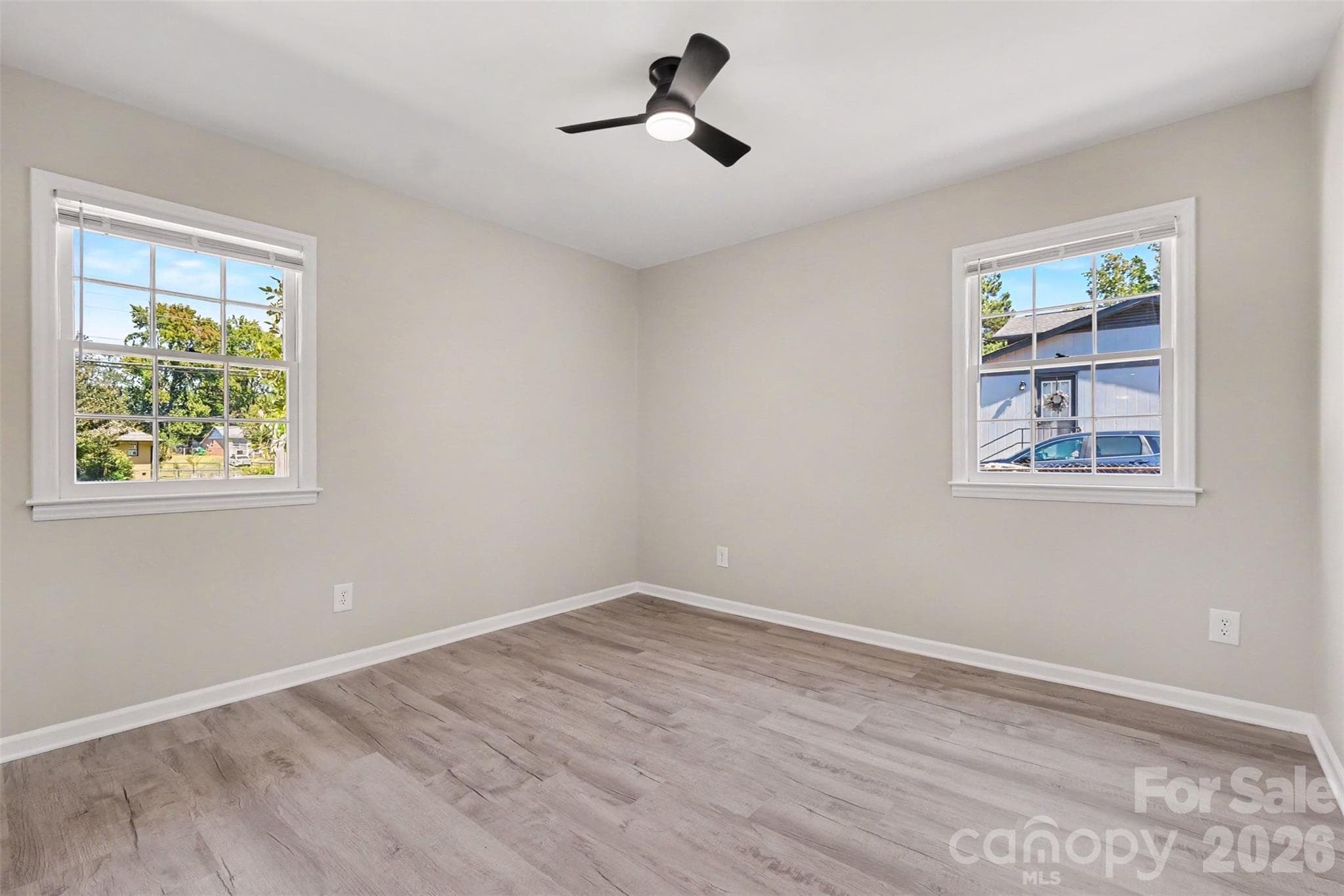 Spacious bedroom featuring a sliding door closet, fresh paint, and updated flooring throughout. - 3801 Hillock Court, Charlotte