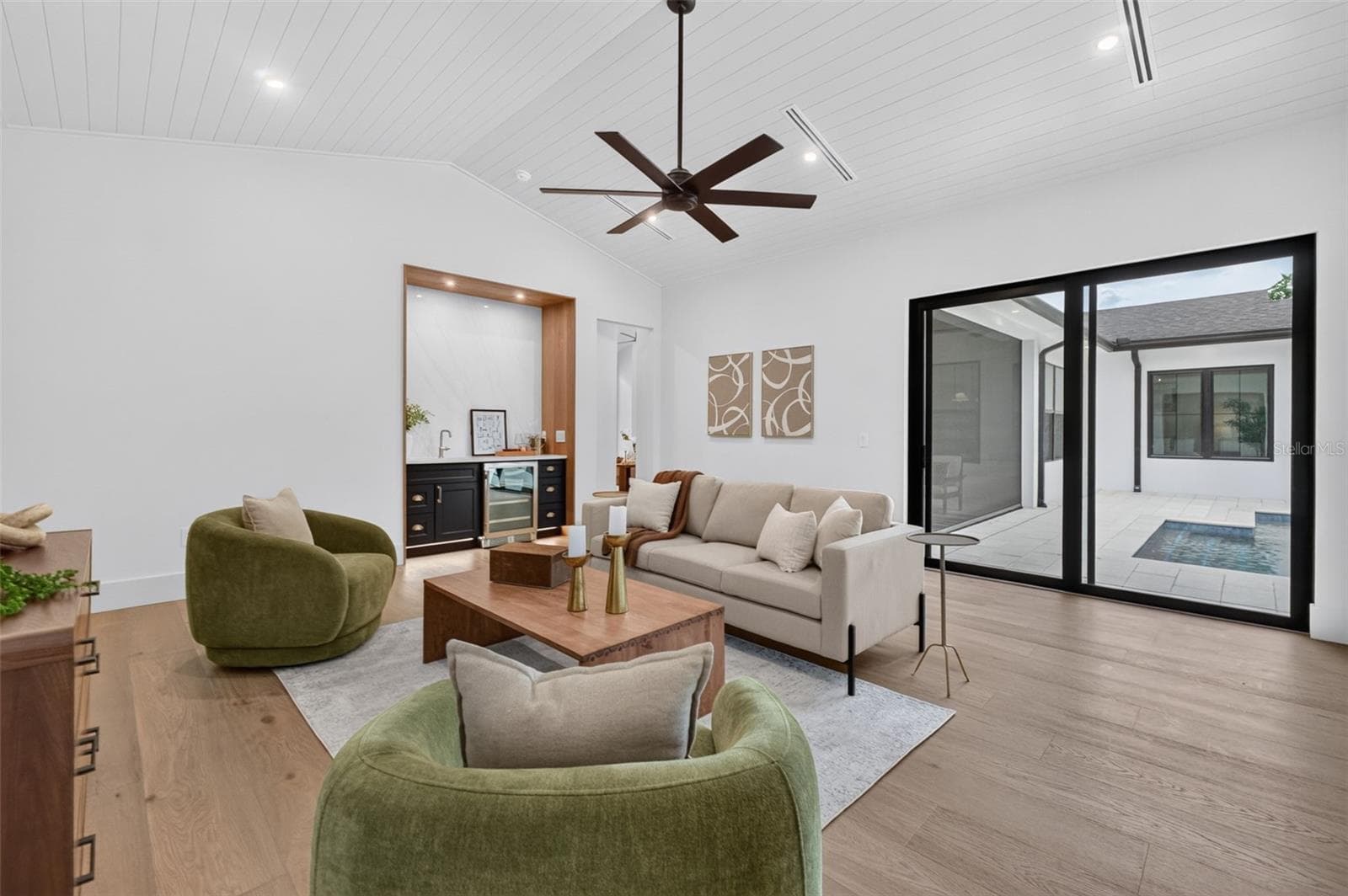 Game room features a wet bar with beverage refrigerator and two large sliding glass doors that provide direct access to pool and covered lanai - 1815 WINDERMERE RD, WINDERMERE