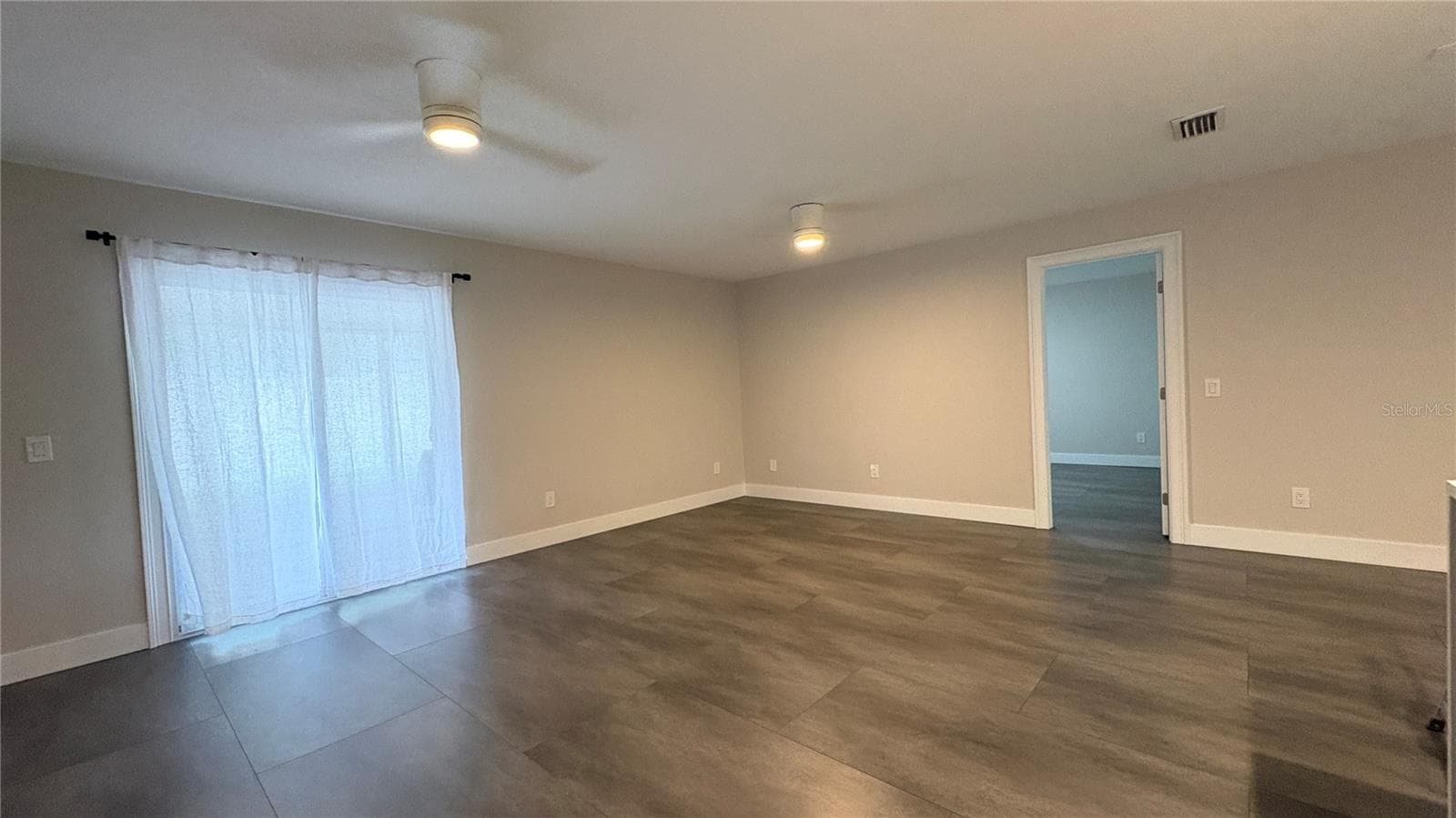 Living/Dining room with slider leading to screened in lanai. - 6001 N LYNN AVE, TAMPA