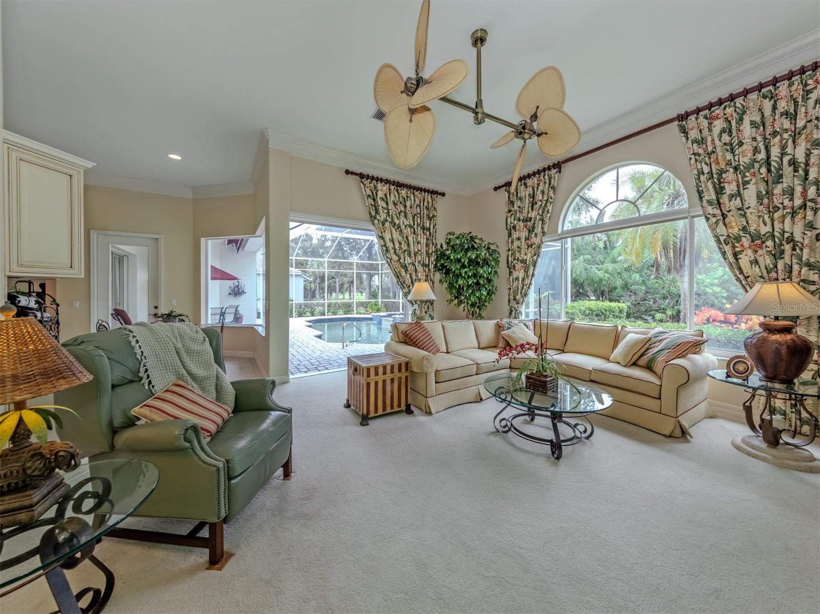 A bright, inviting family room framed by expansive windows and sliding doors that seamlessly connect to the lanai. - 2009 TOCOBAGA LN, NOKOMIS
