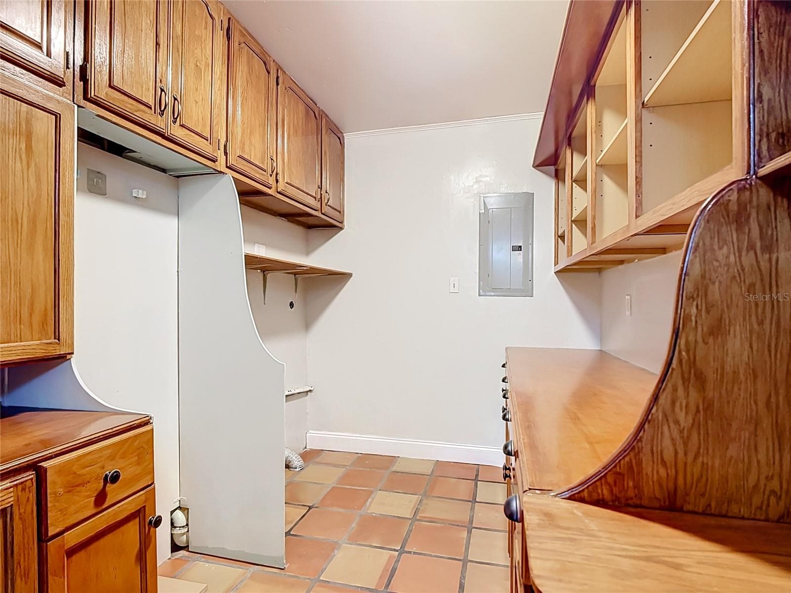 Pantry/storage room with custom cabinetry and laundry hookups. - 112 10TH ST, ST CLOUD