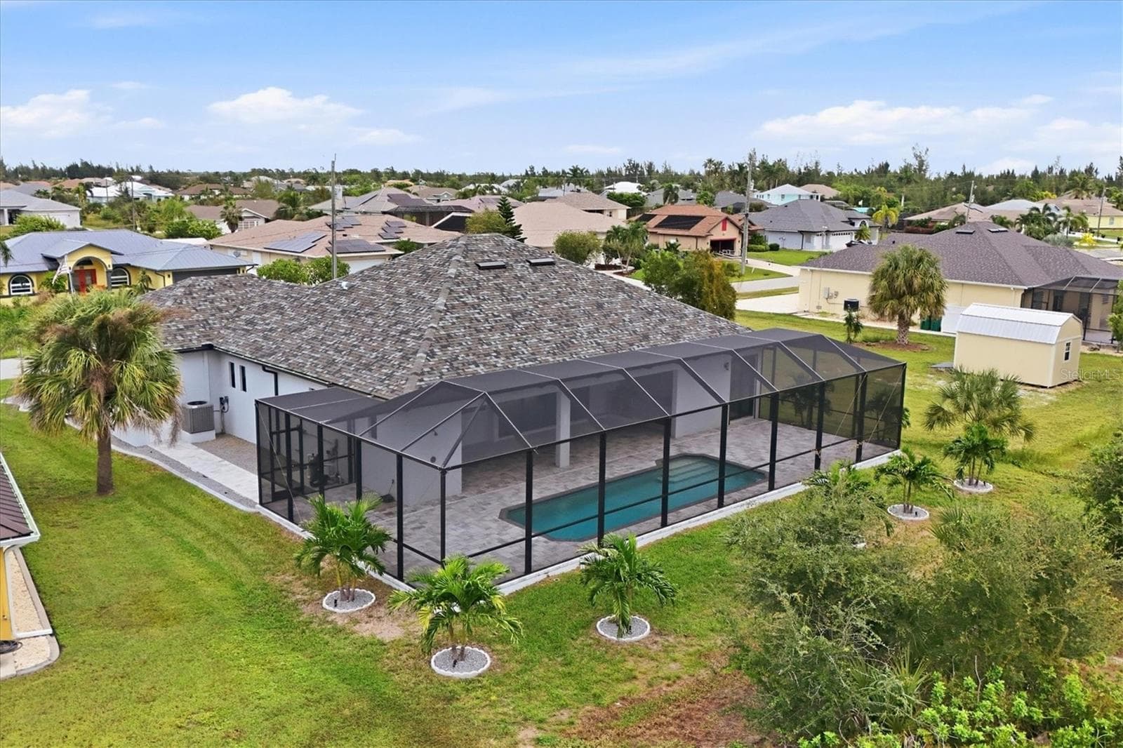 Oversized lanai space with beautiful christmas tree palms bordering the back of the property - 15417 AVERY RD, PORT CHARLOTTE