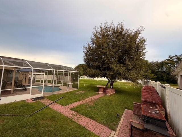 Partial Patio view outside the pool and its enclosure, you can see the external BBQ and kitchen area and the picnic table under the tree - 4030 SANTA BARBARA RD, KISSIMMEE