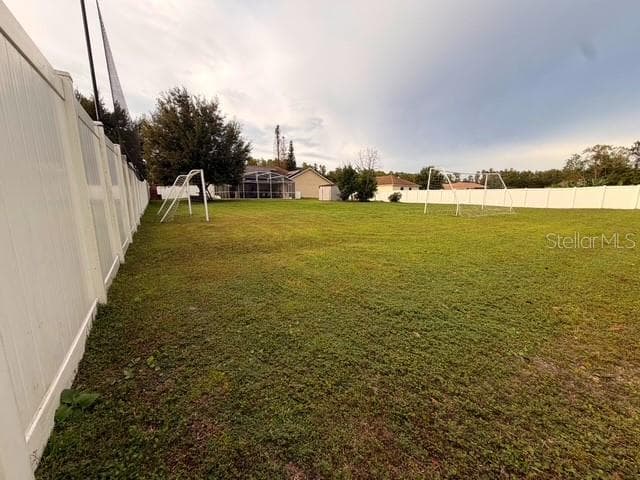 View of the half acre (over 21,000 square feet) LOT, all fenced in White vinyl fence.; Is so large that they practice soccer with the two goals seen here. - 4030 SANTA BARBARA RD, KISSIMMEE