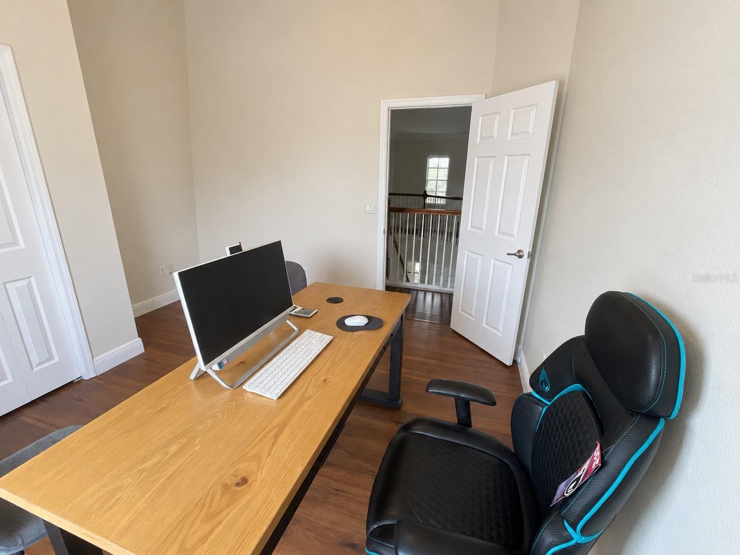 A dedicated office with a large window overlooking the water and ample room for a desk and guest seating. Neutral walls and wood-tone flooring create a simple, comfortable workspace. - 11117 ANCIENT FUTURES DR, TAMPA