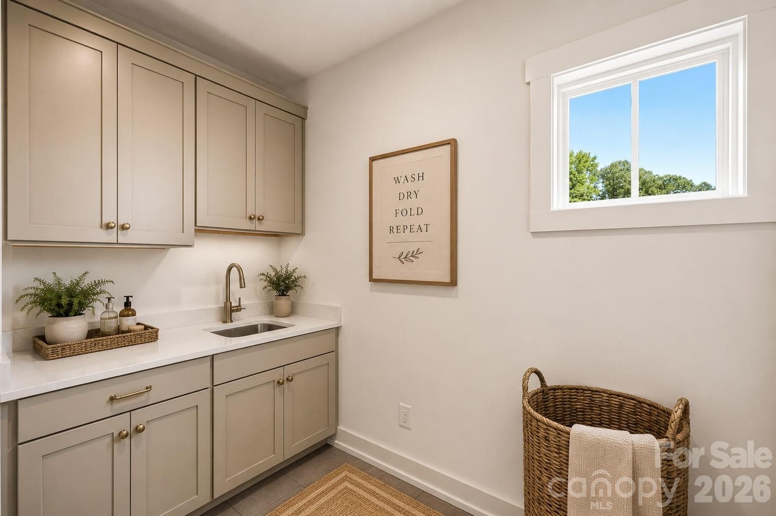 Representative photo- designer laundry room with cabinets, countertop and a laundry sink. - Charlotte