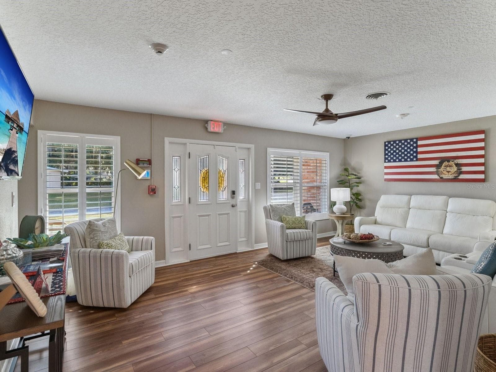 Living room with plantation shutters and LVP flooring - SPRING LAKE MANOR, FRUITLAND PARK