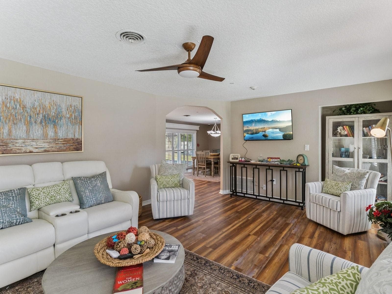 Living room opens to dining through arched doorway - SPRING LAKE MANOR, FRUITLAND PARK