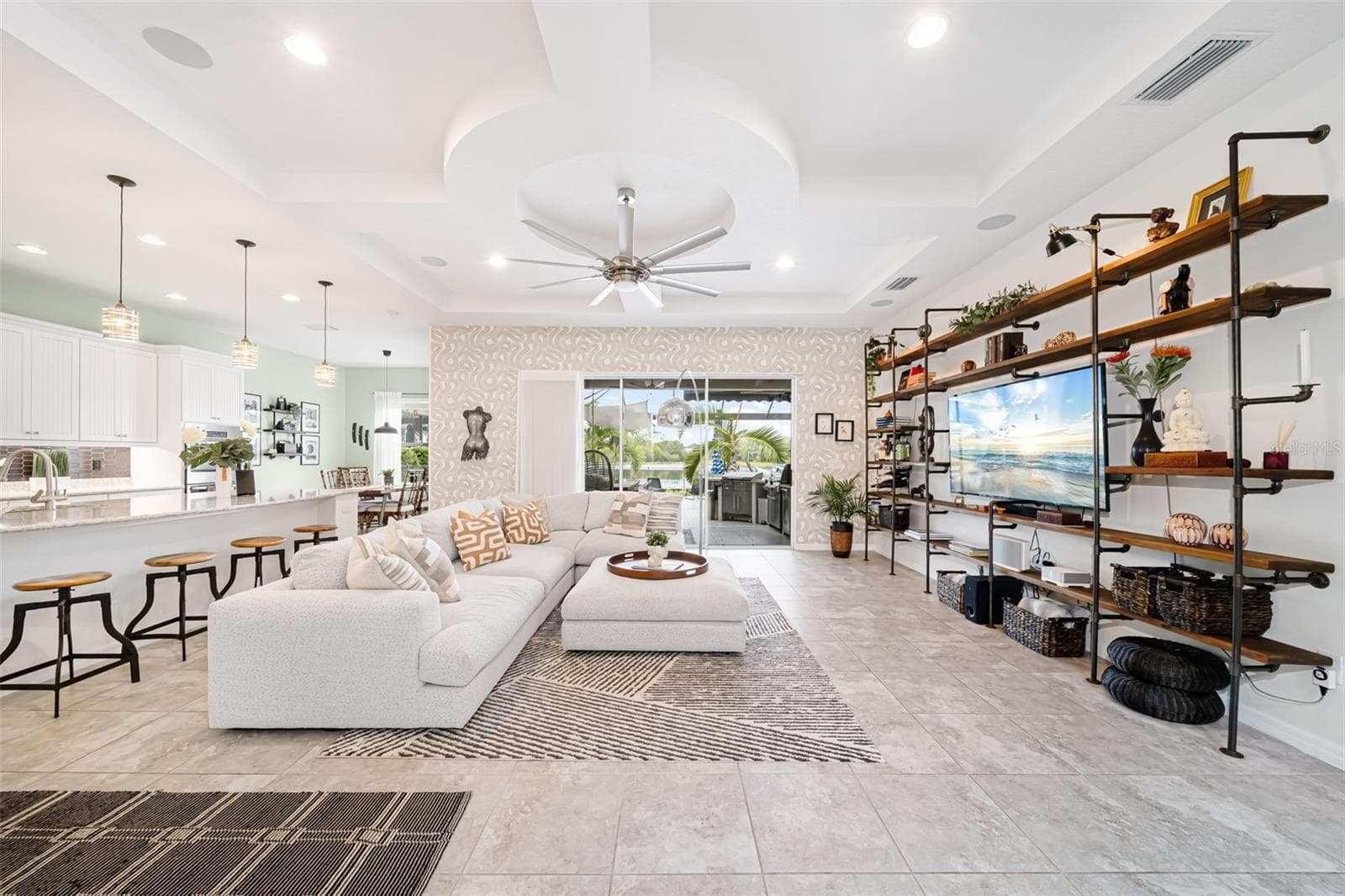 An open-concept living area with custom built-in shelving and a welcoming atmosphere. - 6195 ANISE DR, SARASOTA