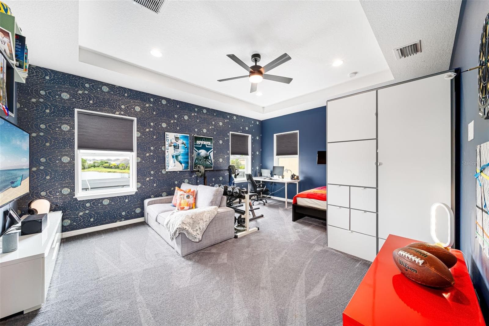 Spacious oversized bedroom showcasing custom built-in shelving and picturesque lake views. - 6195 ANISE DR, SARASOTA