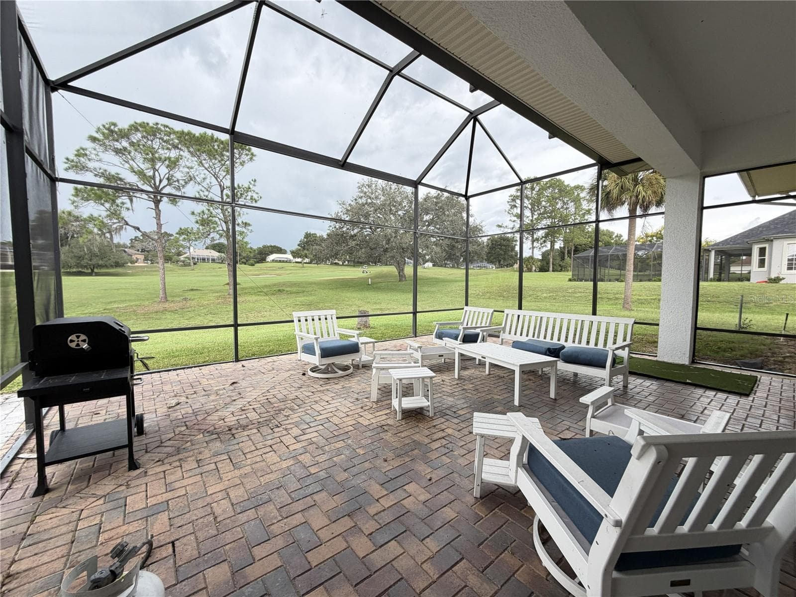 Additional golf-course view from the lanai; portions of lower screening are missing. - 39539 HARBOR HILLS BLVD, LADY LAKE