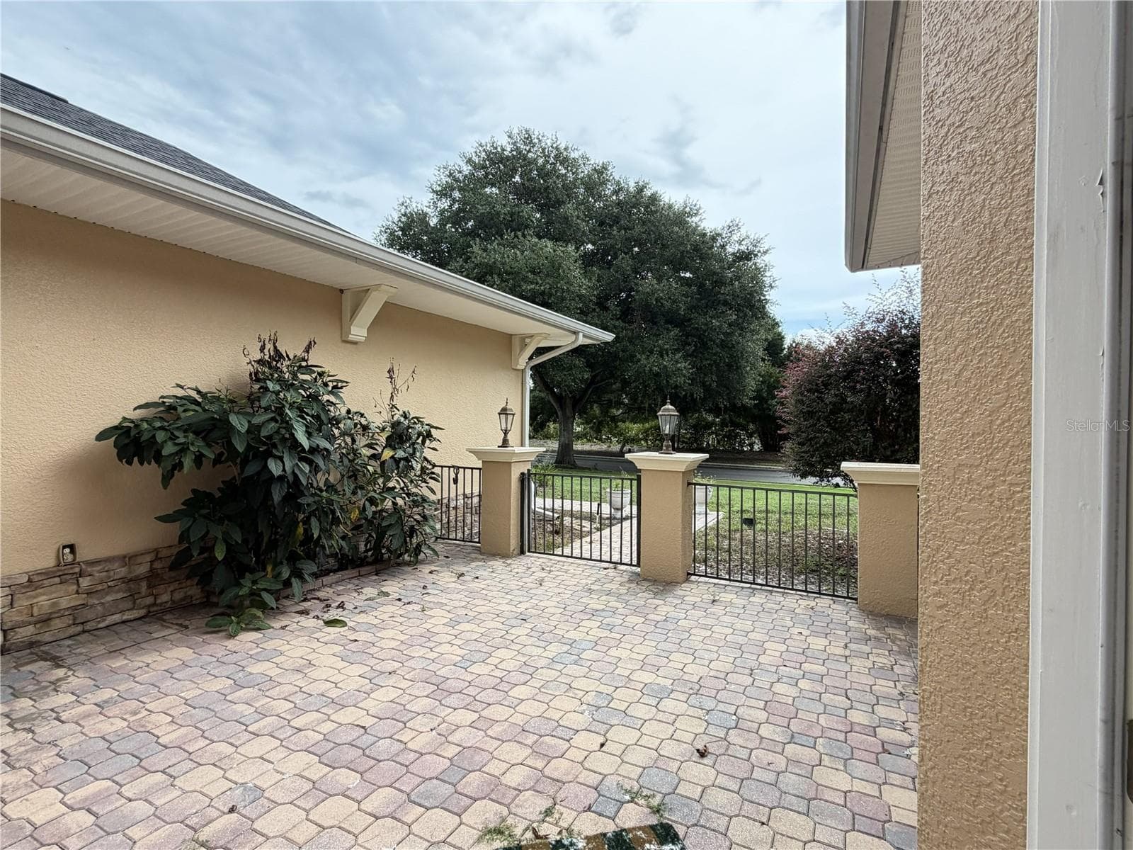 Paver entry courtyard with decorative metal fencing. - 39539 HARBOR HILLS BLVD, LADY LAKE